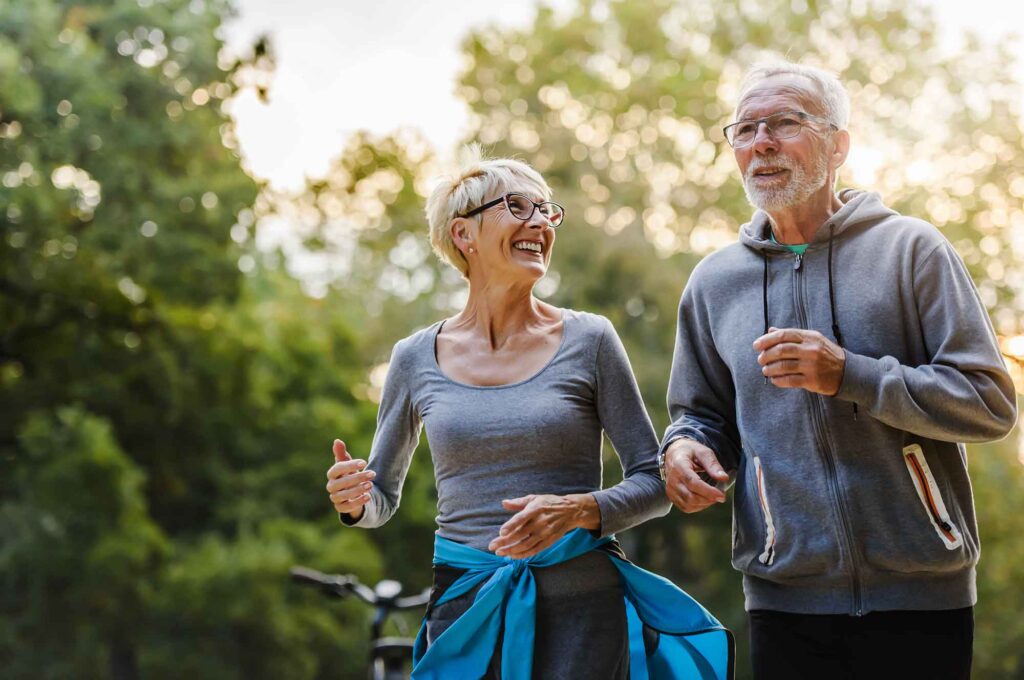 A senior couple goes jogging outdoors