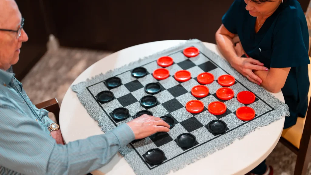 A resident and team member play checkers